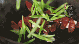 先后下香腸片、四季豆絲均勻翻炒，加適量清水燜煮一下。