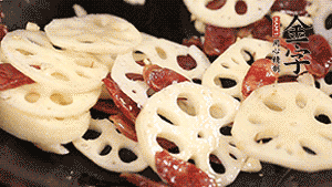 依次下香腸片、藕片翻炒均勻，加適量清水燜熟。