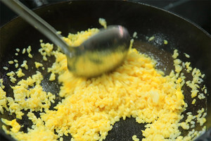 大火加熱炒鍋，再入油，燒到四至五成熱時倒入雞蛋液，在未凝結(jié)之前，加米飯煸炒，不停翻炒并用鍋鏟將成塊的米飯碾開、撥散。