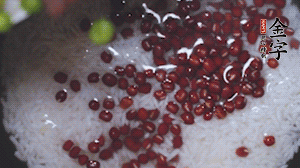 將炒好的食材和大米、紅豆一起放進(jìn)電飯鍋煮。