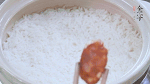 煮開后轉(zhuǎn)小火，當(dāng)米飯出現(xiàn)小孔時(shí)，鋪上金字麻辣香腸。