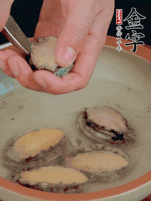鮑魚加鹽、清水浸泡，用勺子挖出鮑魚肉。