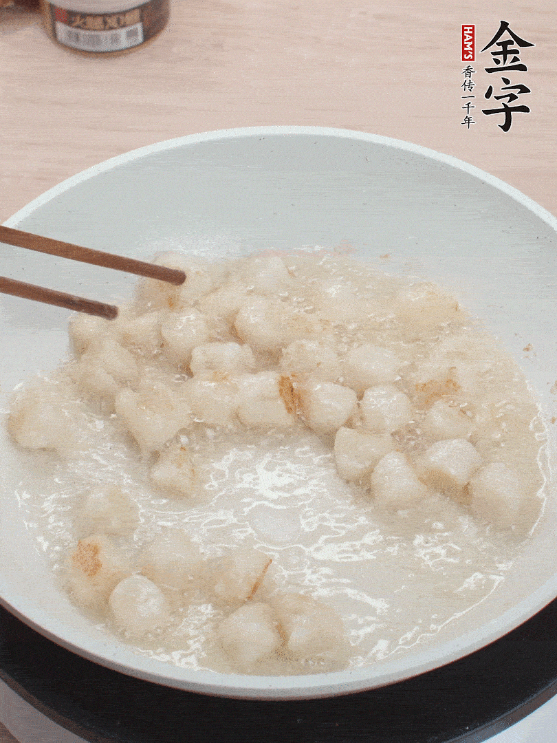 油溫4成熱，鮮貝蘸干淀粉下鍋煎，一面微黃后翻面。