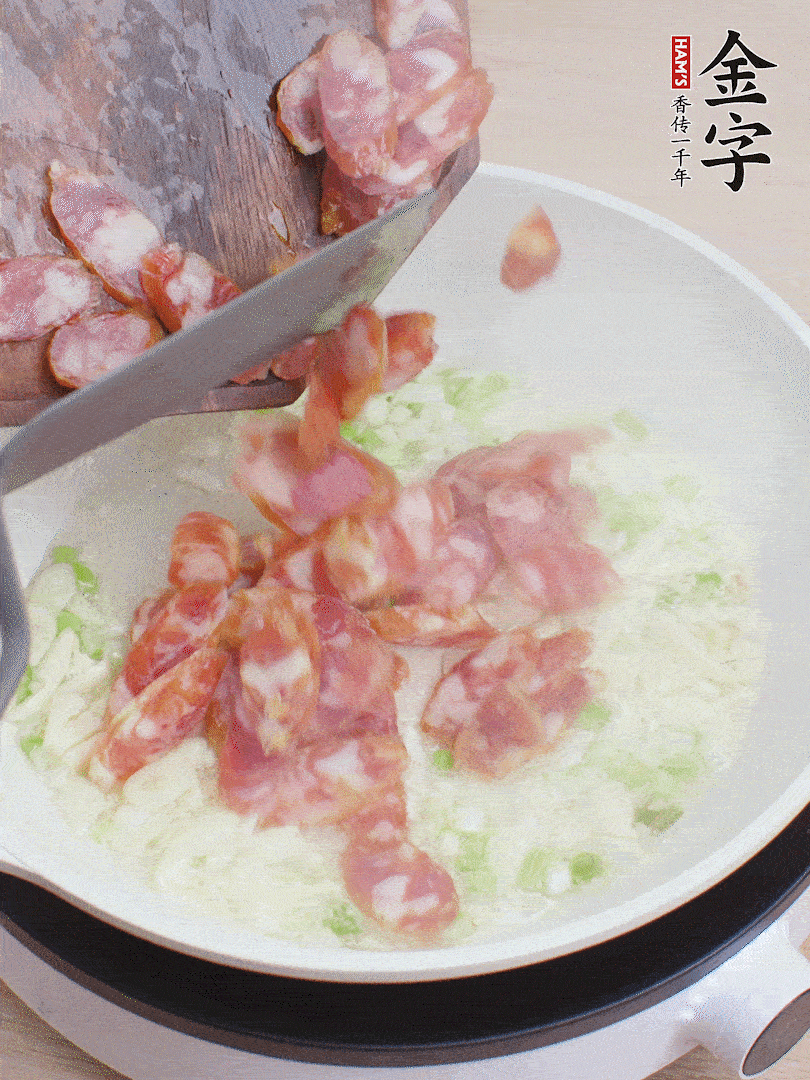 油5成熱，蒜末、蔥白爆香，下香腸炒出香味。