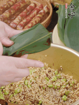 粽葉往下折，完全蓋住，兩側(cè)捏緊。