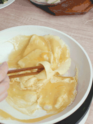 油6成熱時，下雞蛋液，邊緣凝固時翻拌成塊狀。