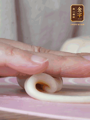 做面劑 油皮按扁，中間包入一個油酥，邊緣收緊捏死。包好的面劑按扁，用搟面杖搟壓成橢圓形。從底部向上卷成筒狀，用保鮮膜蓋好松弛15分鐘，再把筒狀縱向搟壓成長條狀。再卷一次，松弛20分鐘