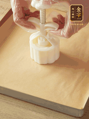 取一個(gè)面團(tuán)，捏扁，中間厚，四周薄。虎口往上推，直到收口，把餅胚放入模具里，壓2-3下