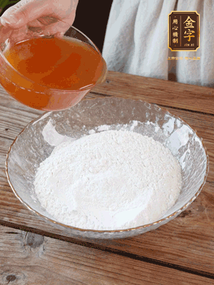 轉(zhuǎn)化糖漿、枧水、花生油攪拌均勻，加入面粉混合，醒發(fā)2小時(shí)。捏成23g一個(gè)的小球