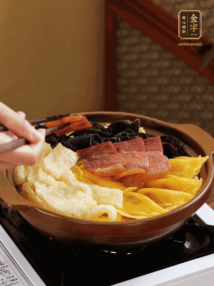 砂鍋底部鋪上娃娃菜，依次擺上肉皮、蛋餃、黑木耳、火腿